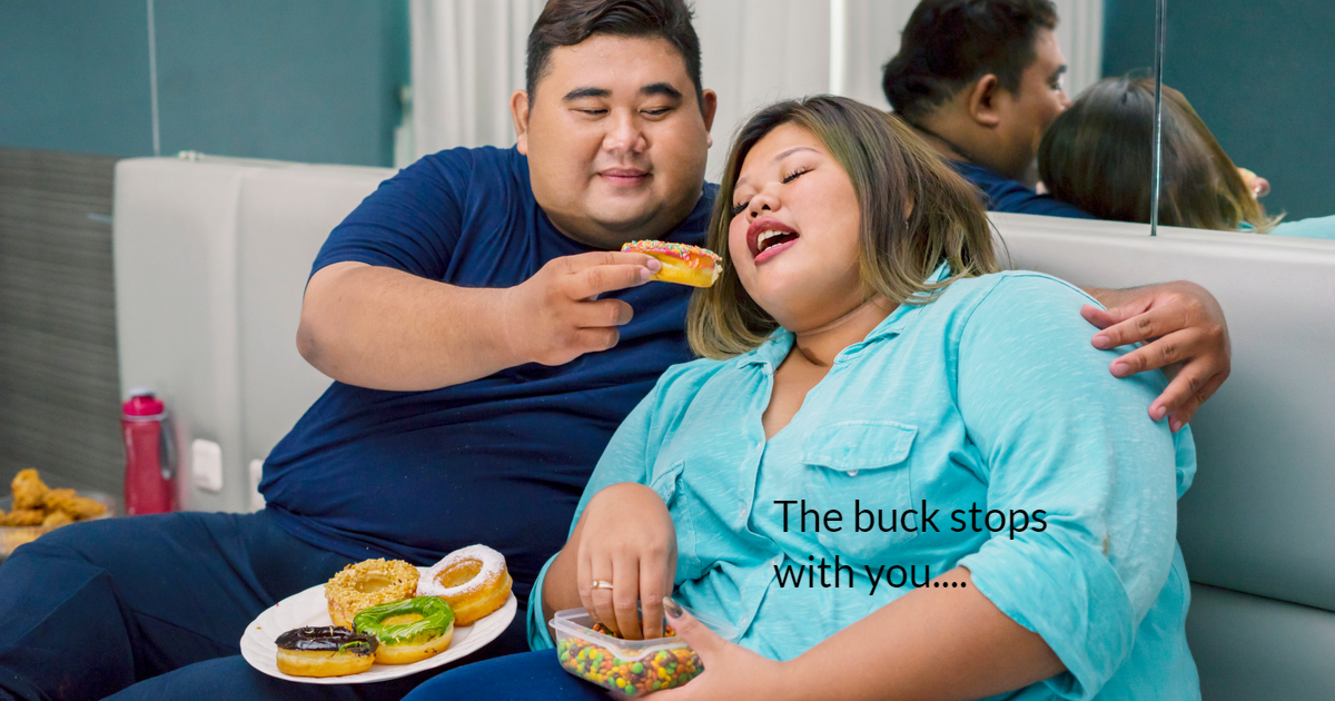 A fat couple sitting in bed. The man is feeding the woman a doughnut and the woman is holding a container with sweets.